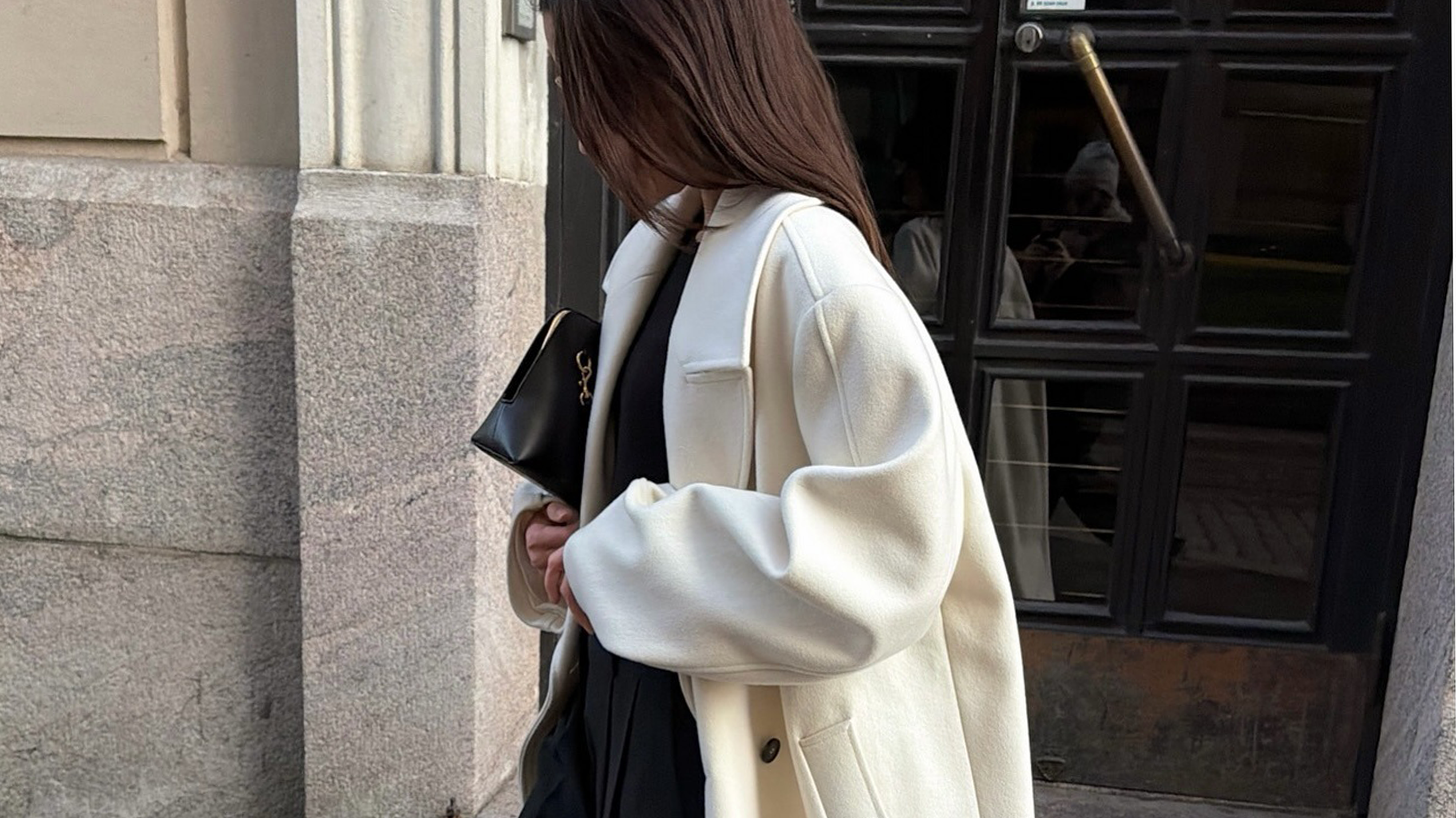 Woman wearing white coat.