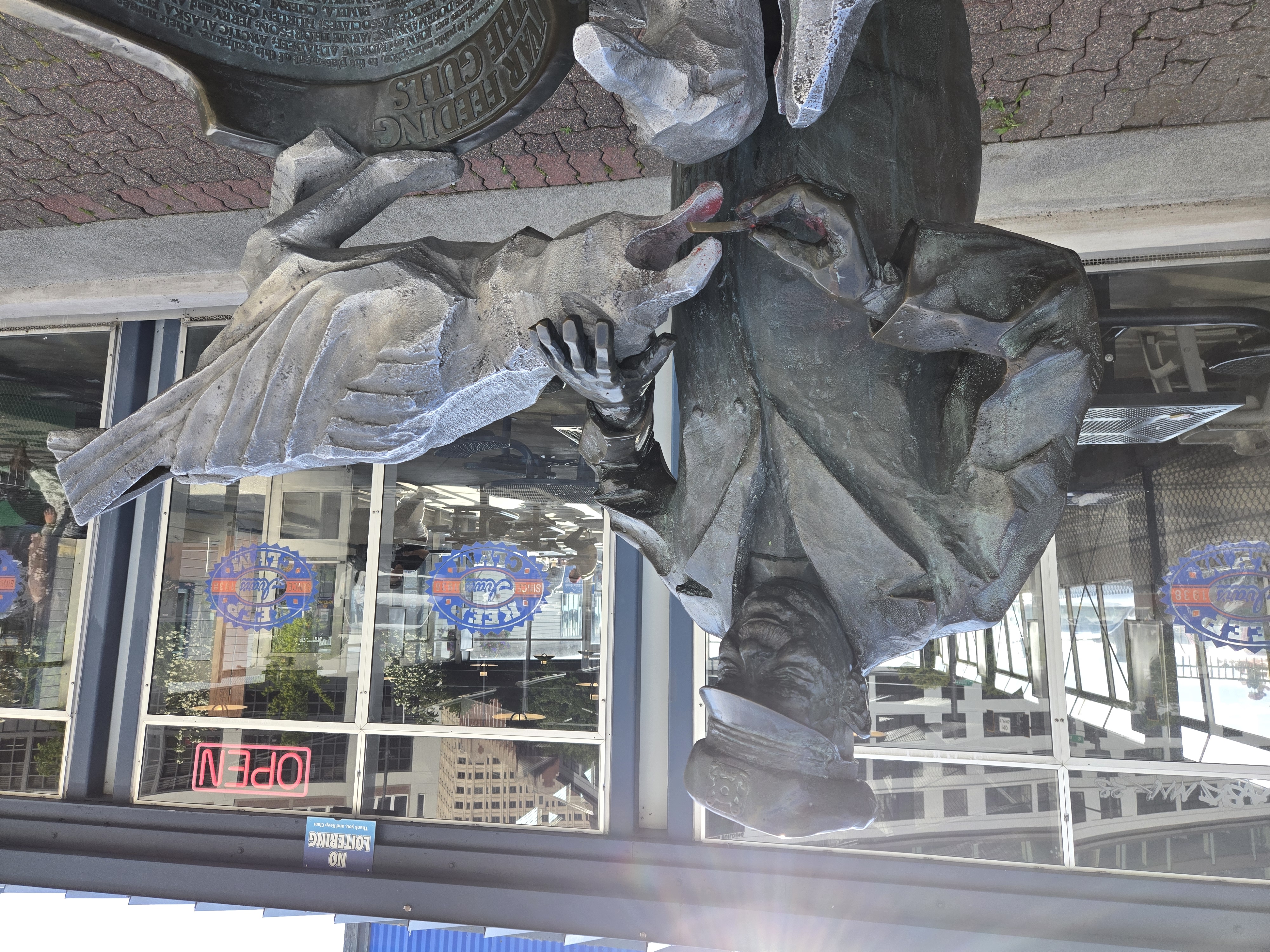 A statue of a man feeding a seagull