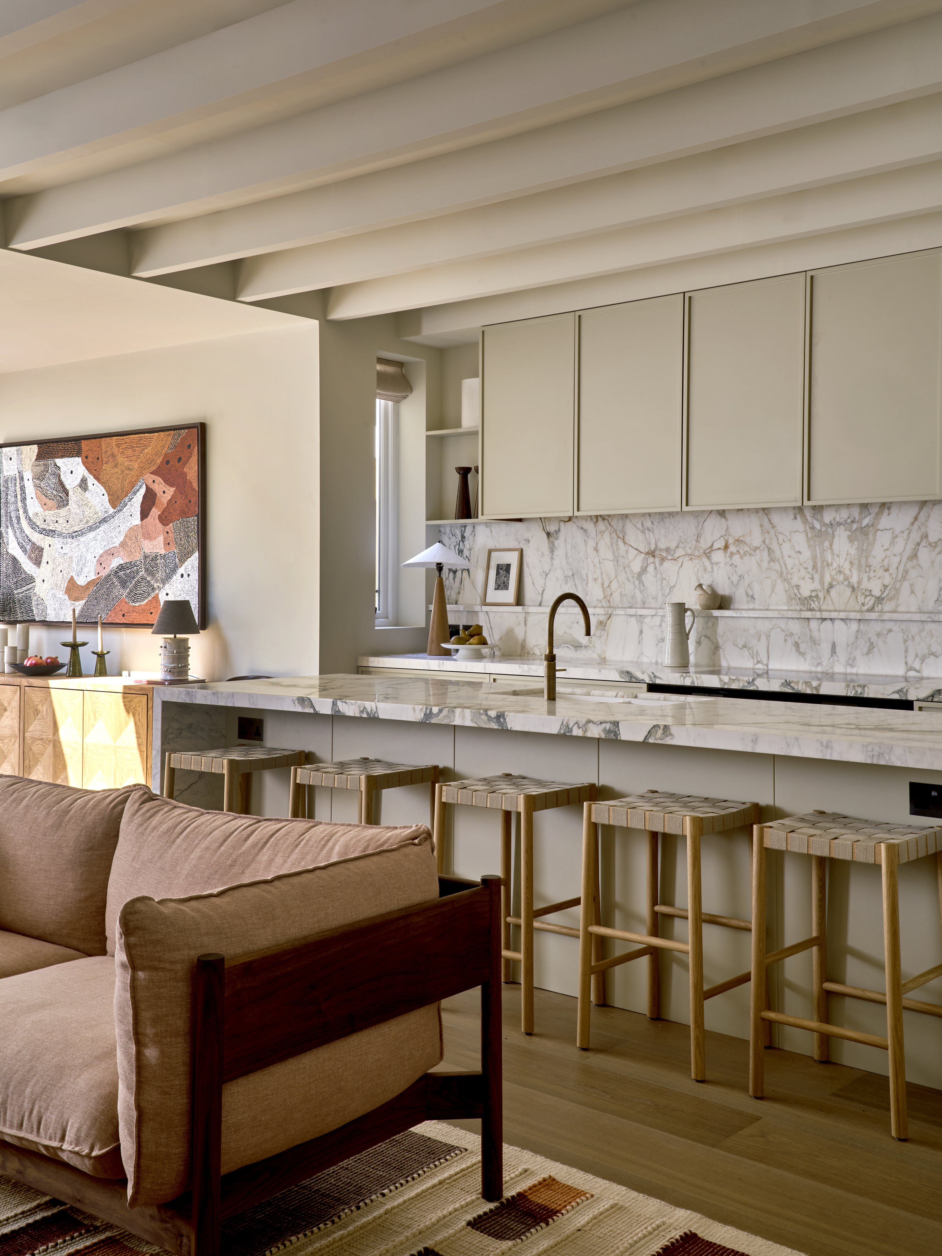 A low-profile sofa placed close to an open kitchen