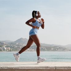A woman running wondering, how long does it take to get fit