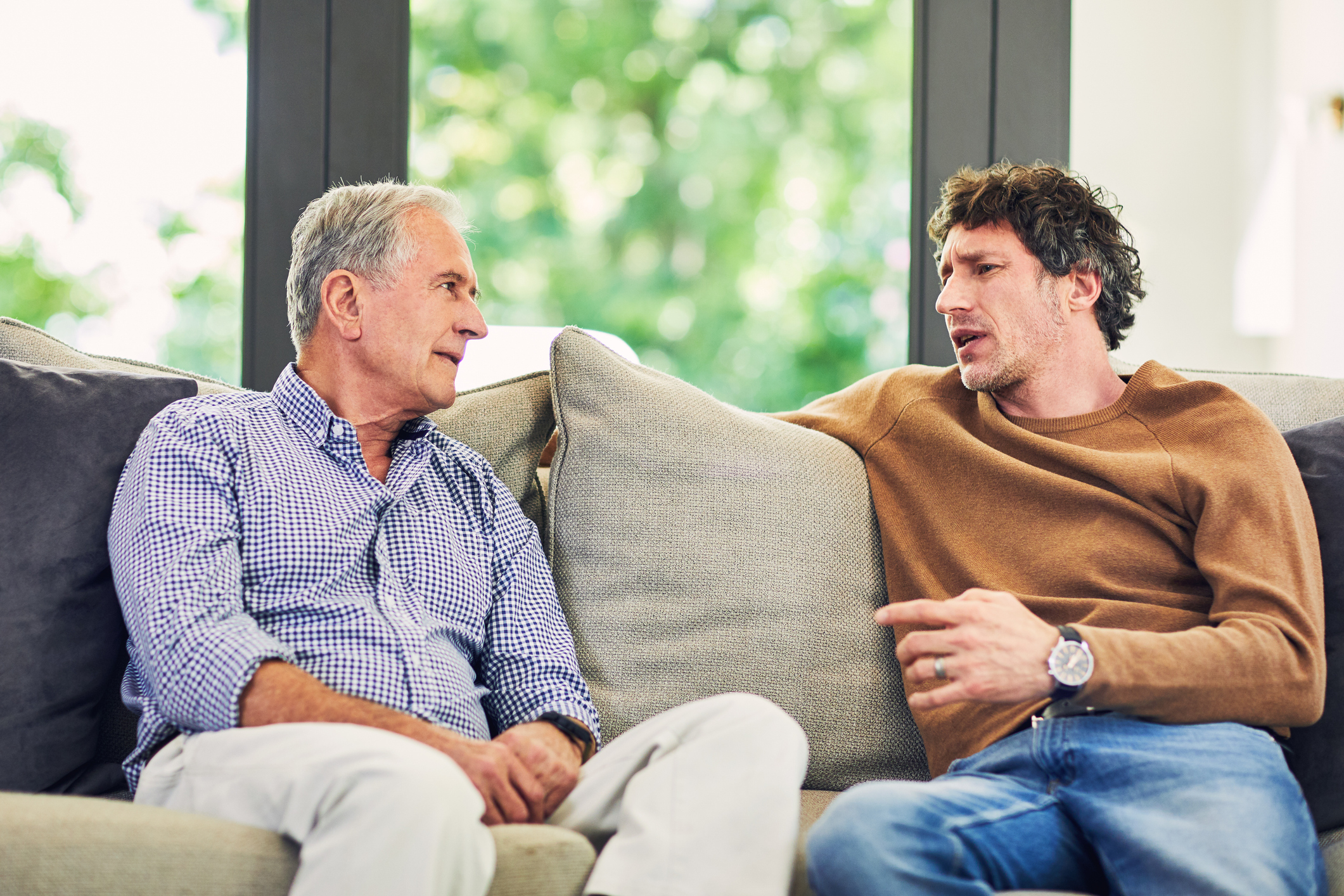 Shot of a mature man and his elderly father sitting on the sofa at home and chatting