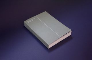 A grey book on a blue surface.