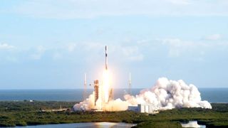 falcon 9 rocket launches up into a blue sky 