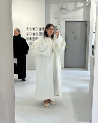 Laura Reilly wearing a large poplin white jacket from Lii Studio with cream Maison Margiela Tabi flats.