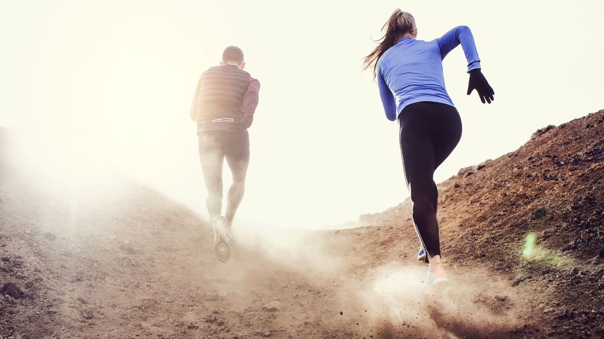 Man and woman running uphill