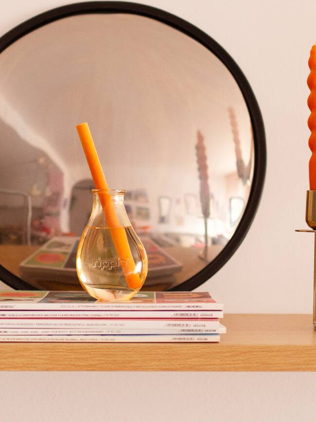 A yellow glass diffuser with a single reed from ripple+