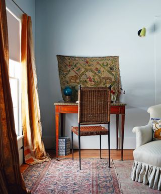Wooden desk, orange curtains, blue walls