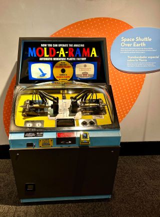 A Mold-A-Rama machine with the space shuttle over Earth mold is seen at the Museum of Science & Industry in Chicago as part of the exhibit, "Mold-A-Rama: Molded for the Future."