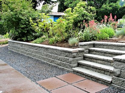 A stone retaining wall under a garden