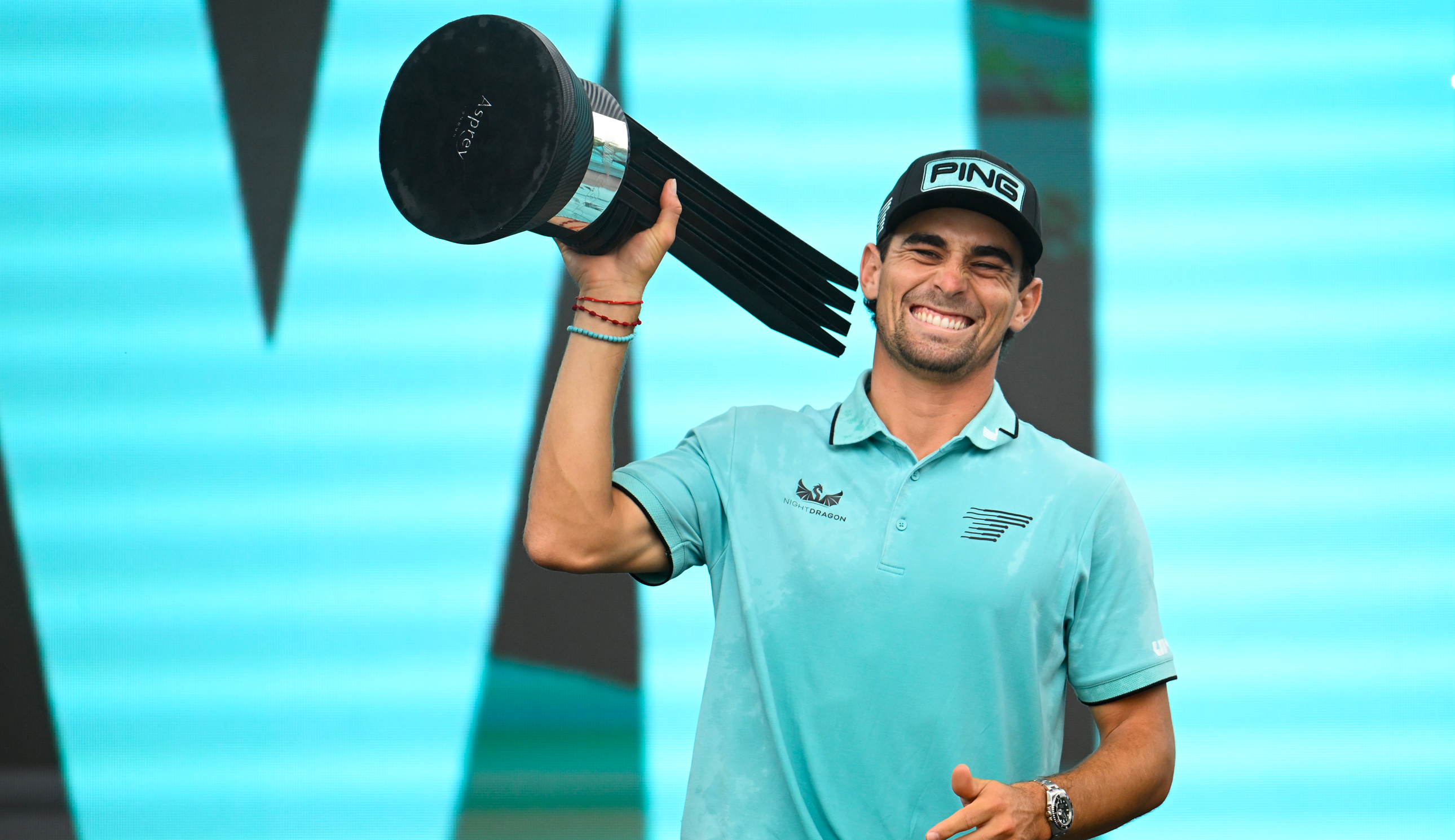Joaquin Niemann holds a trophy