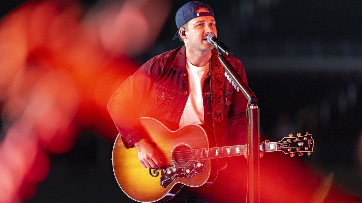 Morgan Wallen playing guitar and singing as he performs at the Billboard Music Awards