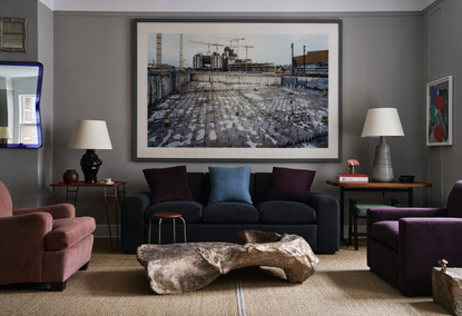 Two armchairs and a couch encircle a metal stone coffee table in the NYC showroom of Robert Stilin.