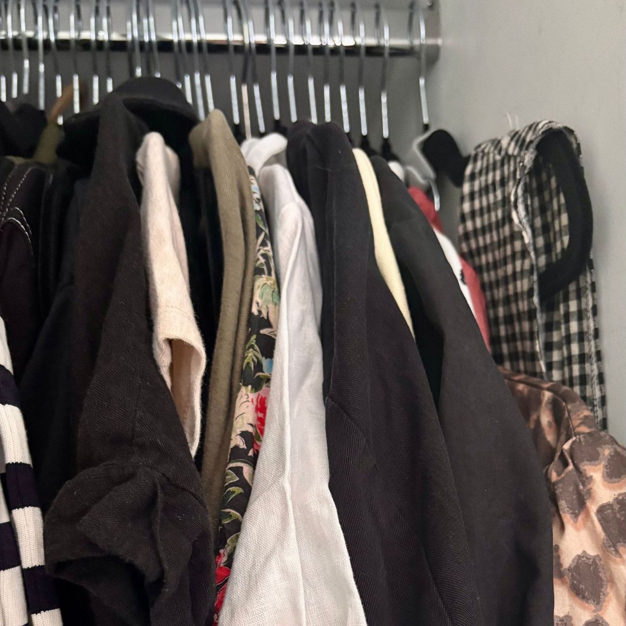 Clothes hanging from hangers in a wardrobe