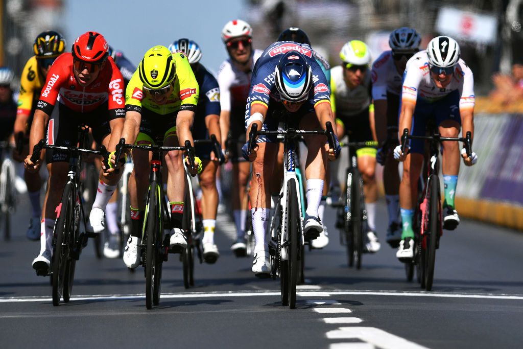 MIDDELKERKE BELGIUM JUNE 26 LR Arnaud De Lie of Belgium and Team Lotto Soudal Milan Menten of Belgium and Team Bingoal Pauwels Sauces WB and Tim Merlier of Belgium and Team Alpecin Fenix sprint at finish line during the 123rd Belgian Road Championship 2022 Mens Road Race a 2087km one day race from Middelkerke to Middelkerke BKMiddelkerke on June 26 2022 in Middelkerke Belgium Photo by Luc ClaessenGetty Images