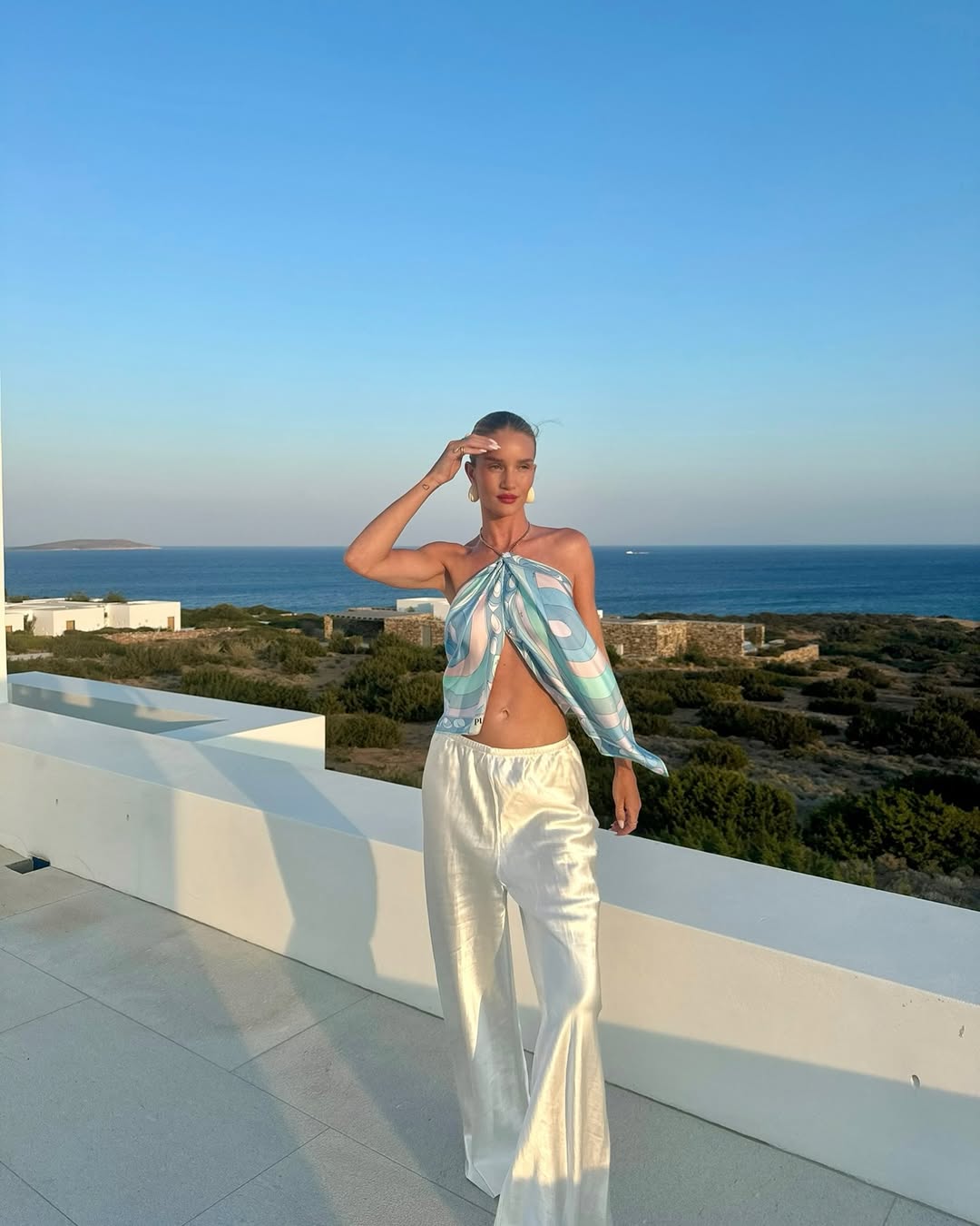 Rosie Huntington-Whiteley in a blue, pink, white Pucci halter top and white satin pants