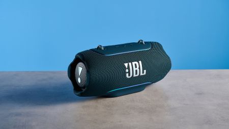 the JBL Xtreme 5 bluetooth speaker in blue shown with the rugged carry strap and buttons
