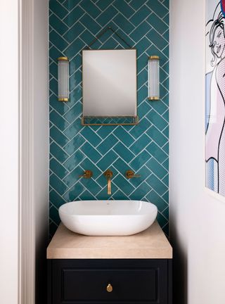 cloakroom with turquoise tiles and rounded white basin