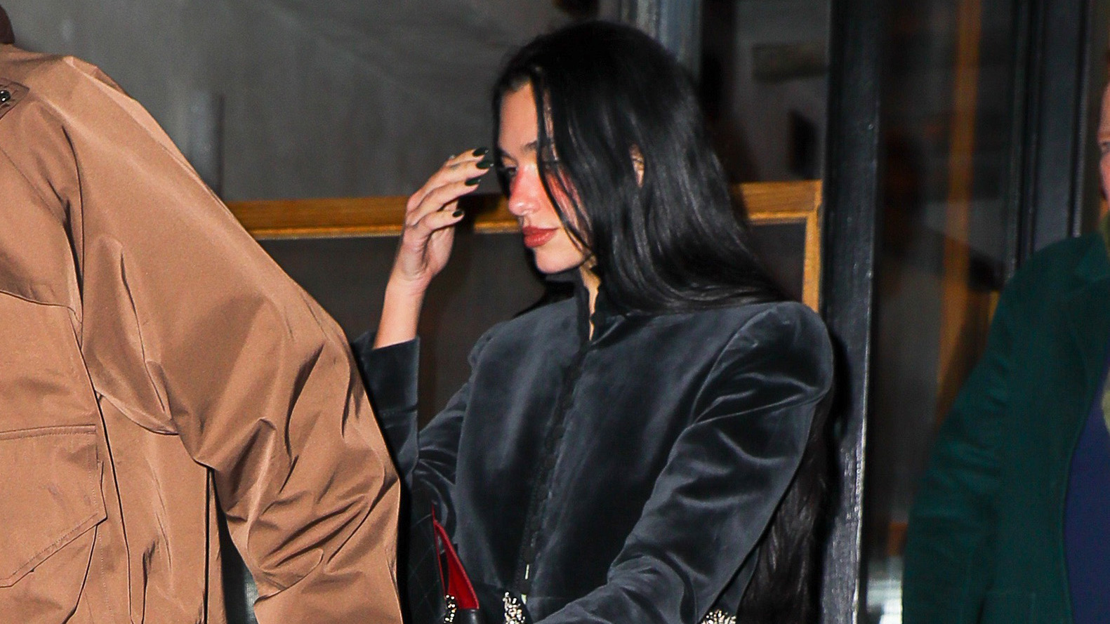 Dua Lipa wearing a cropped black velvet jacket with dark denim jeans and zebra-print pumps in NYC
