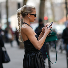 woman with blonde plait pony tail looking at her phone1380977892