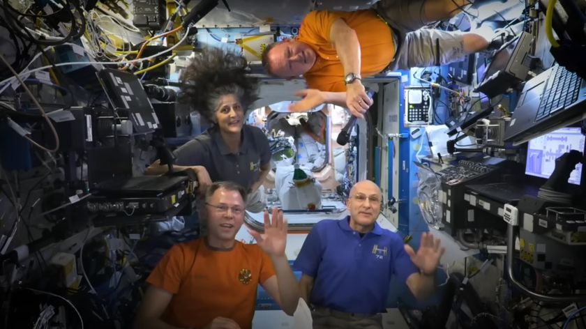 Four people float on the ISS amid lots of tech.