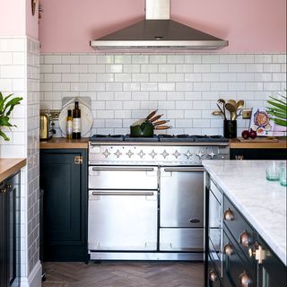 kitchen with pink wall and cabinet with wooden flooring