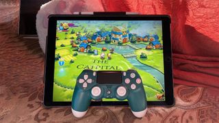 An iPad playing a game with a PS4 controller placed in front of it.