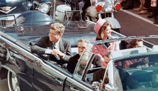 The president and first lady smile at the crowds lining their motorcade route in Dallas minutes before Kennedy was assassinated