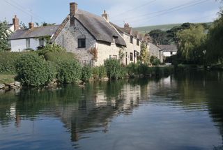 A cottage with a river running alongside it