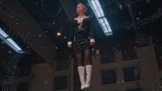 Ruby Sunday wrapped in music hanging in the air in Doctor Who with snow falling around her.