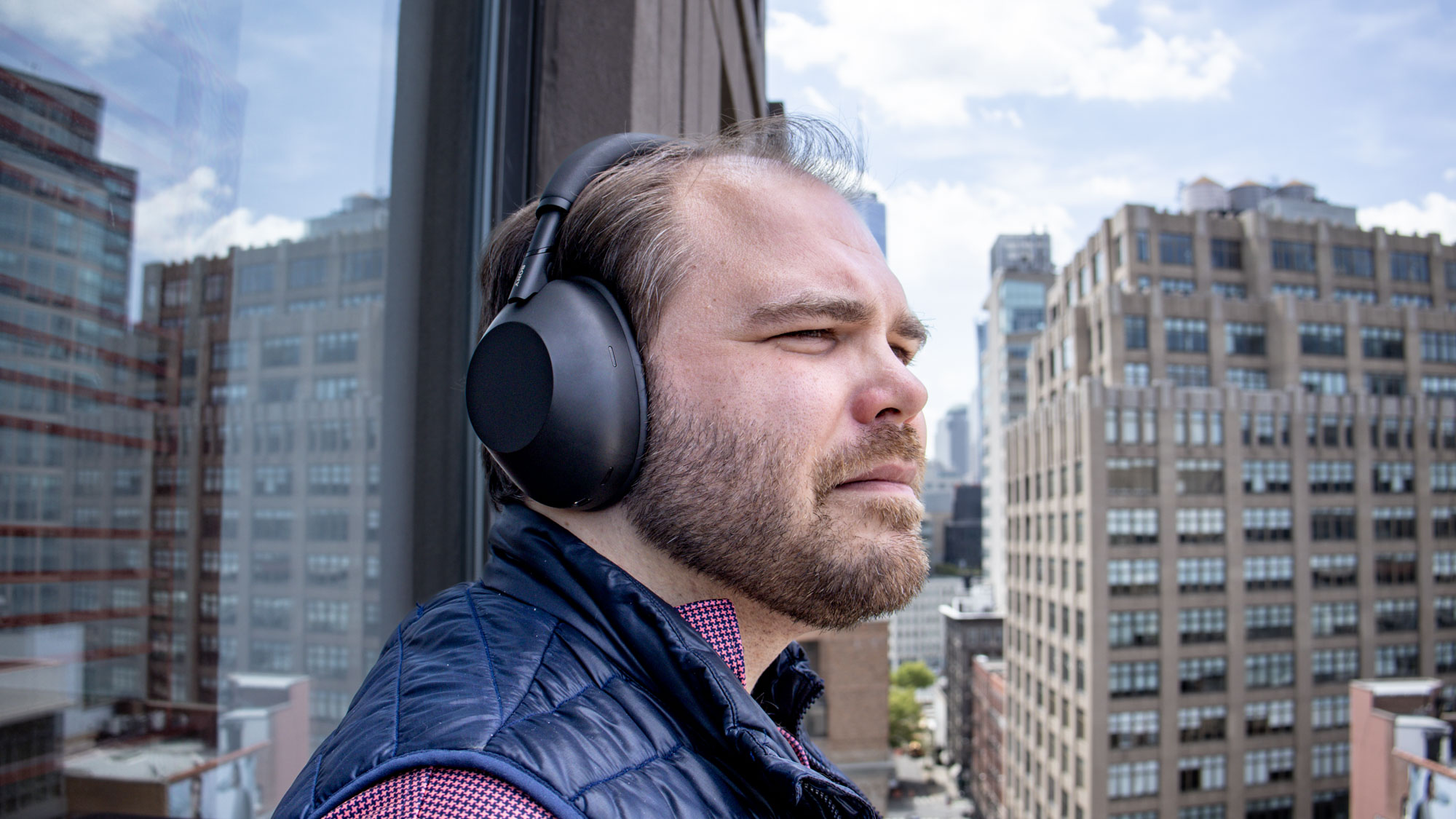 A man wearing black Sony WH-1000XM6 noise-cancelling headphones