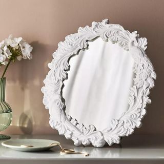 Regine Vanity Mirror against a pale pink wall.