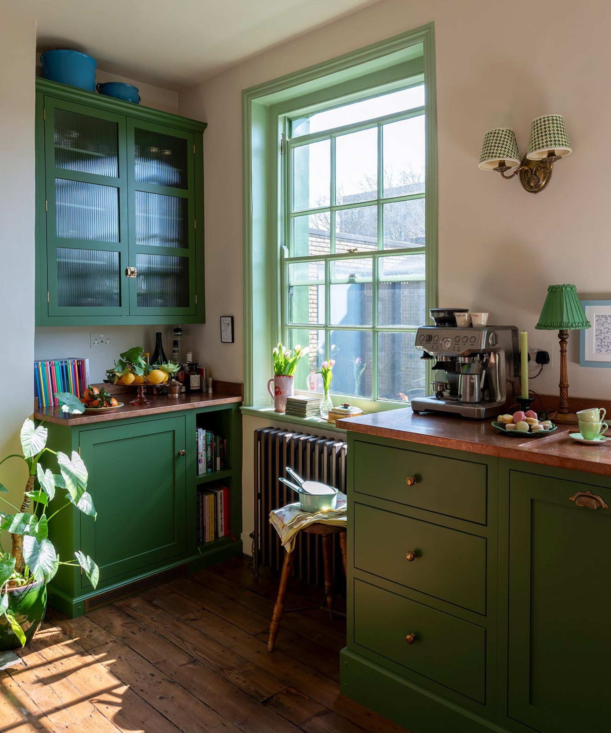 A small green kitchen with original wooden flooring