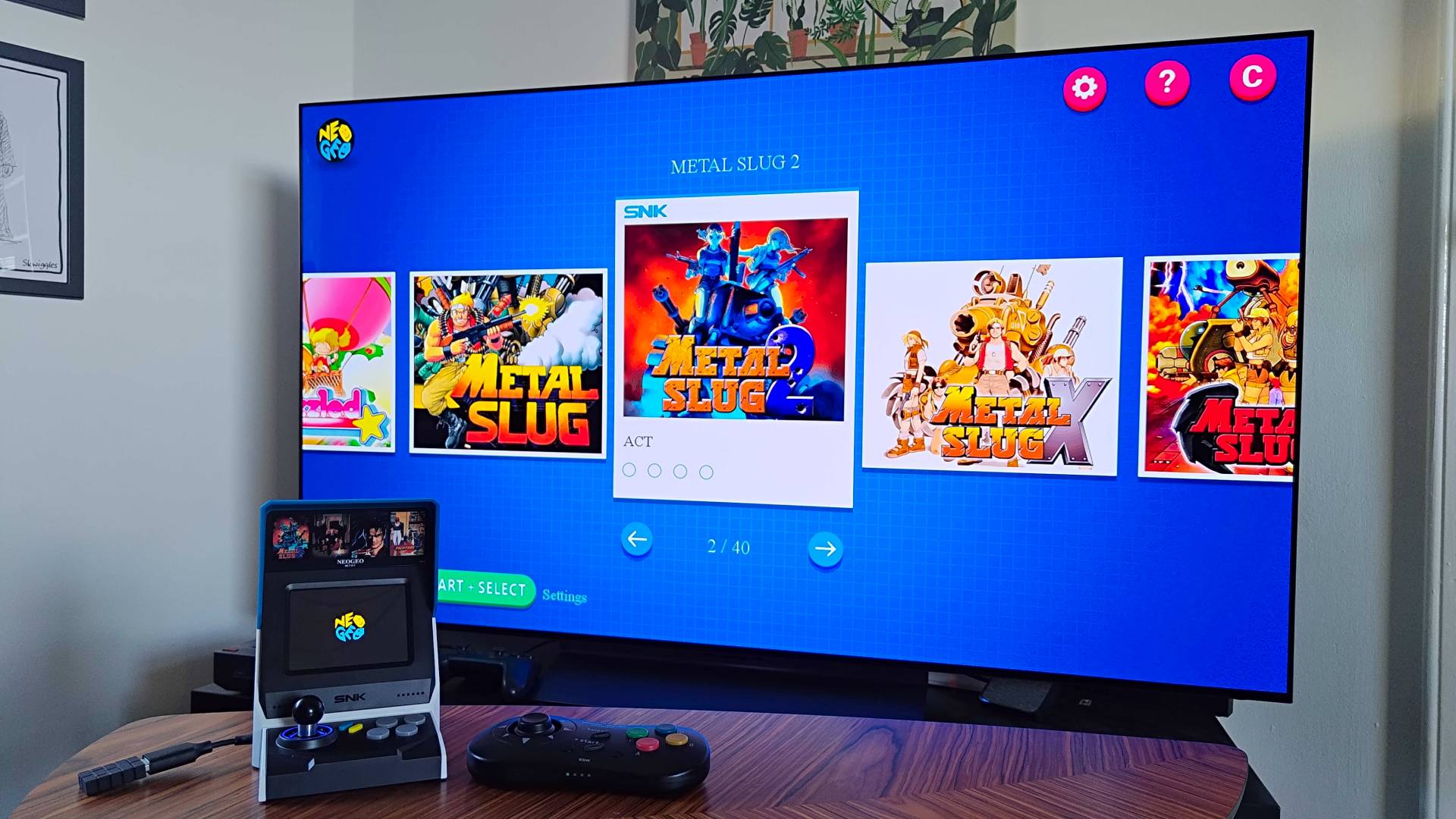 Neo Geo Mini plugged into LG OLED C4 TV with main game menu displayed and Metal Slug 2 selected. 