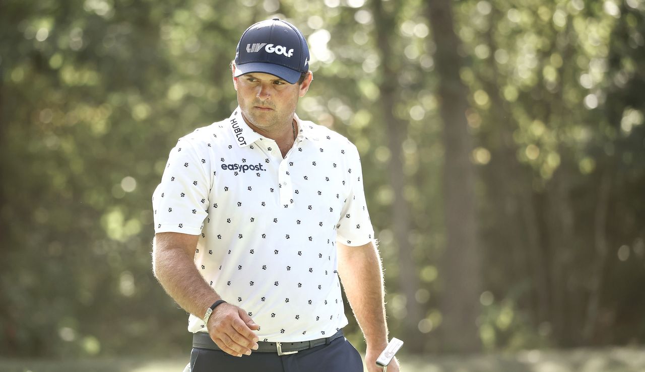 Reed looks on with his putter in hand