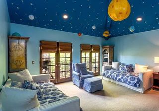 bedroom with blue walls bed and universe theme on ceiling