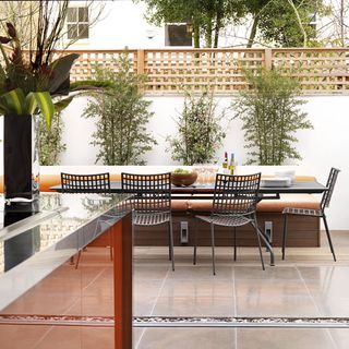 kitchen outdoor area with white wall and dining table and chairs