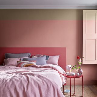 Light pink painted bedroom with double bed, bedside table