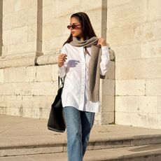 A woman walks outside wearing Everlane