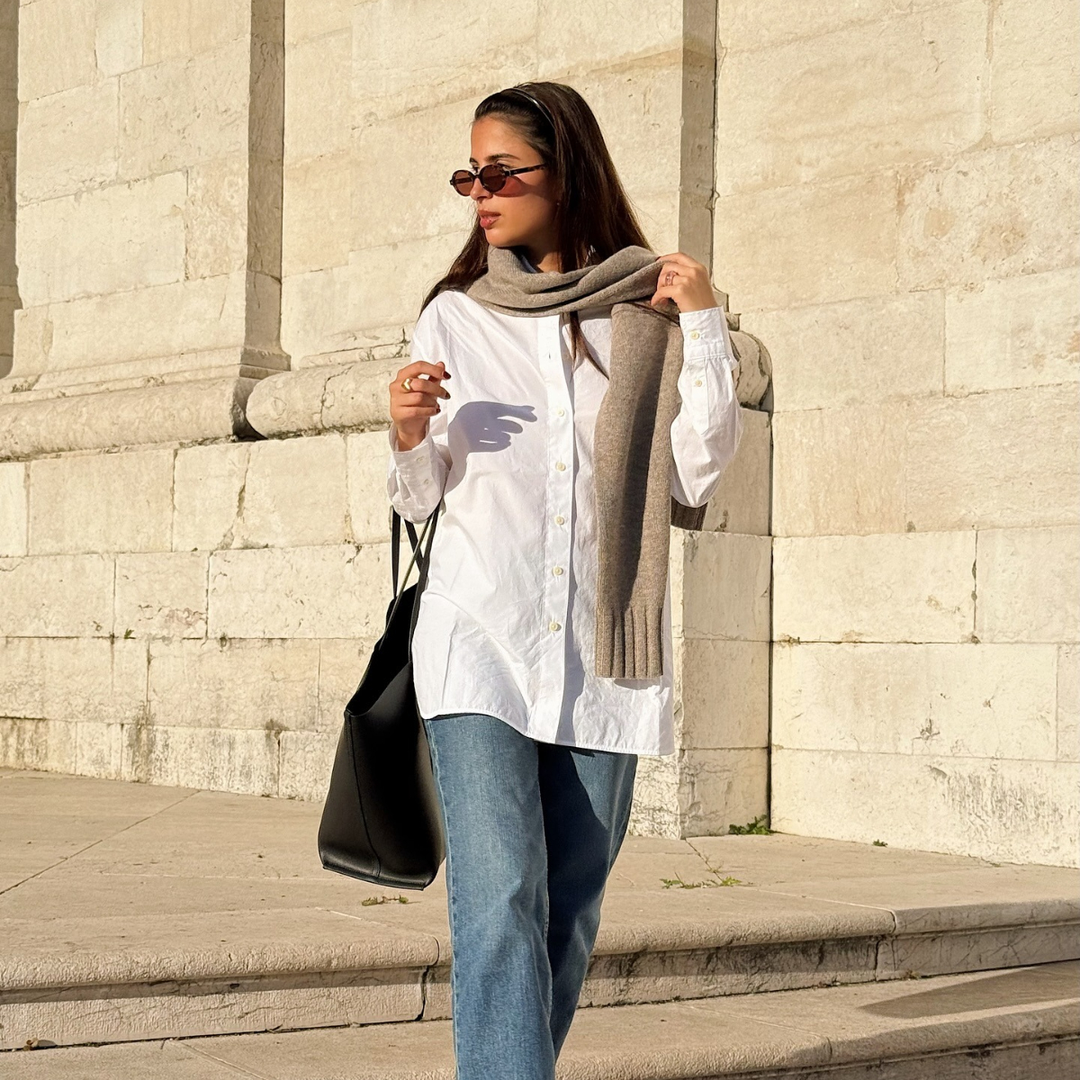 A woman walks outside wearing Everlane