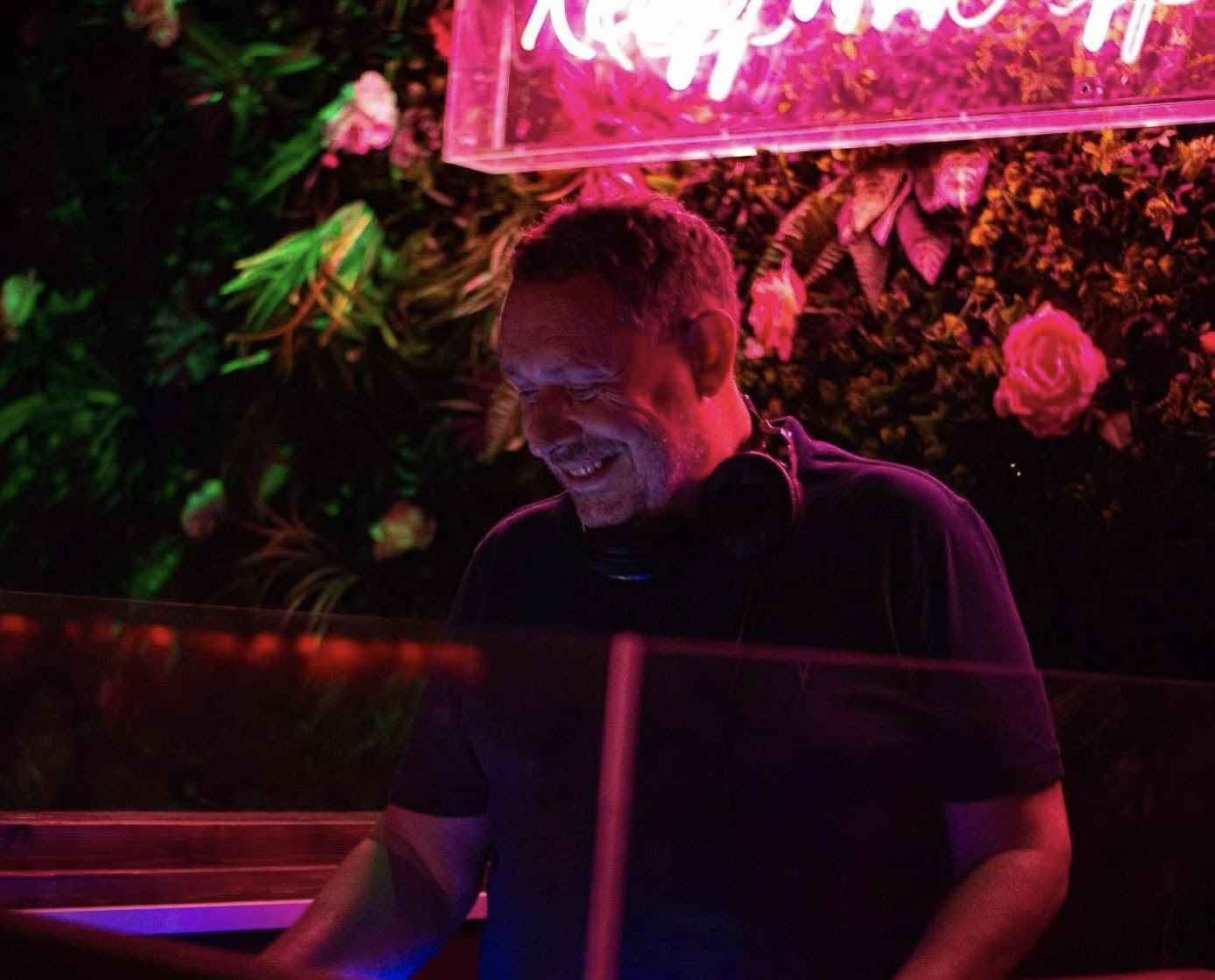 Curtis Lewis smiling as he mixes music.