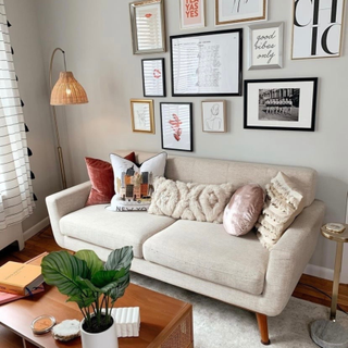 Gallery wall idea featuring assorted framed prints and typography above modern sofa in cozy living room.