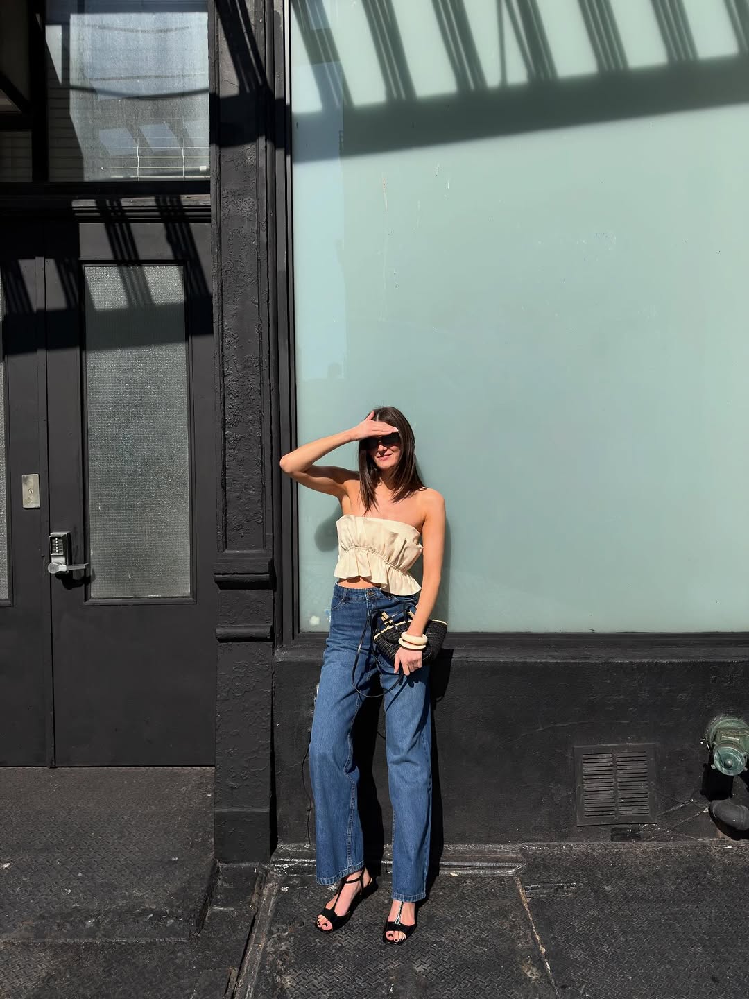 Image of a woman wearing jeans and strapless top, best summer denim outfit inspiration 2026.