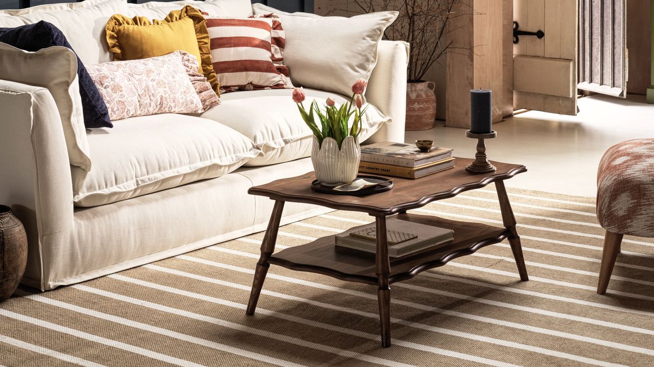 A living room with a ridged pillar candle on a coffee table