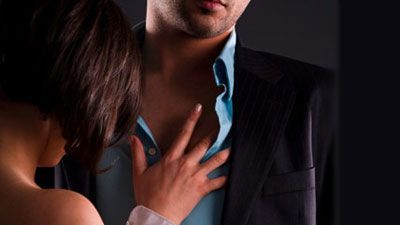 woman with her shirt half off touching man's chest