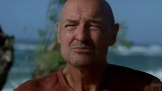 Terry O'Quinn standing on a beach with the ocean behind him in Lost