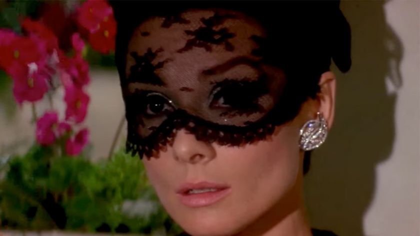 A lose up of Audrey Hepburn with a lace mask on in How To Steal A Million