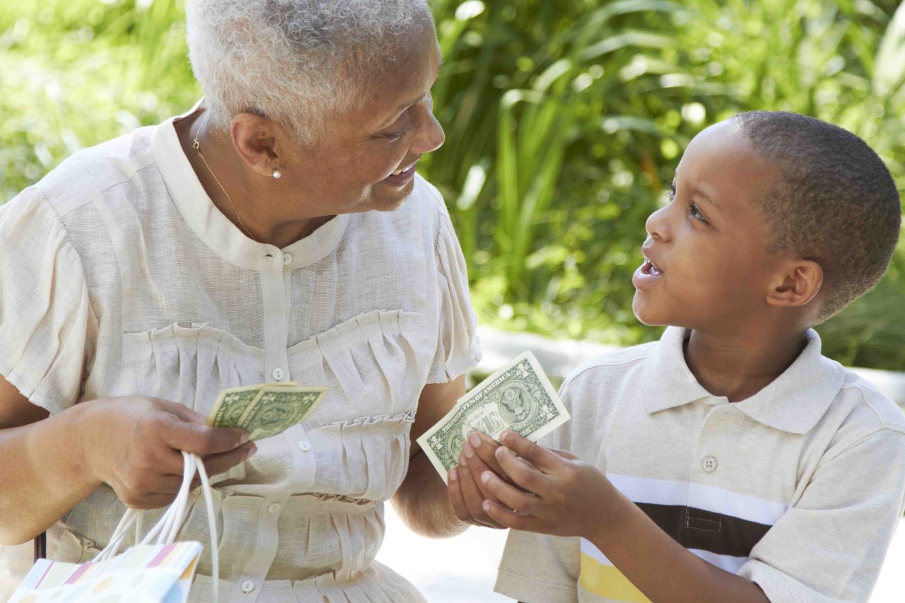 An older woman giving money to a child.