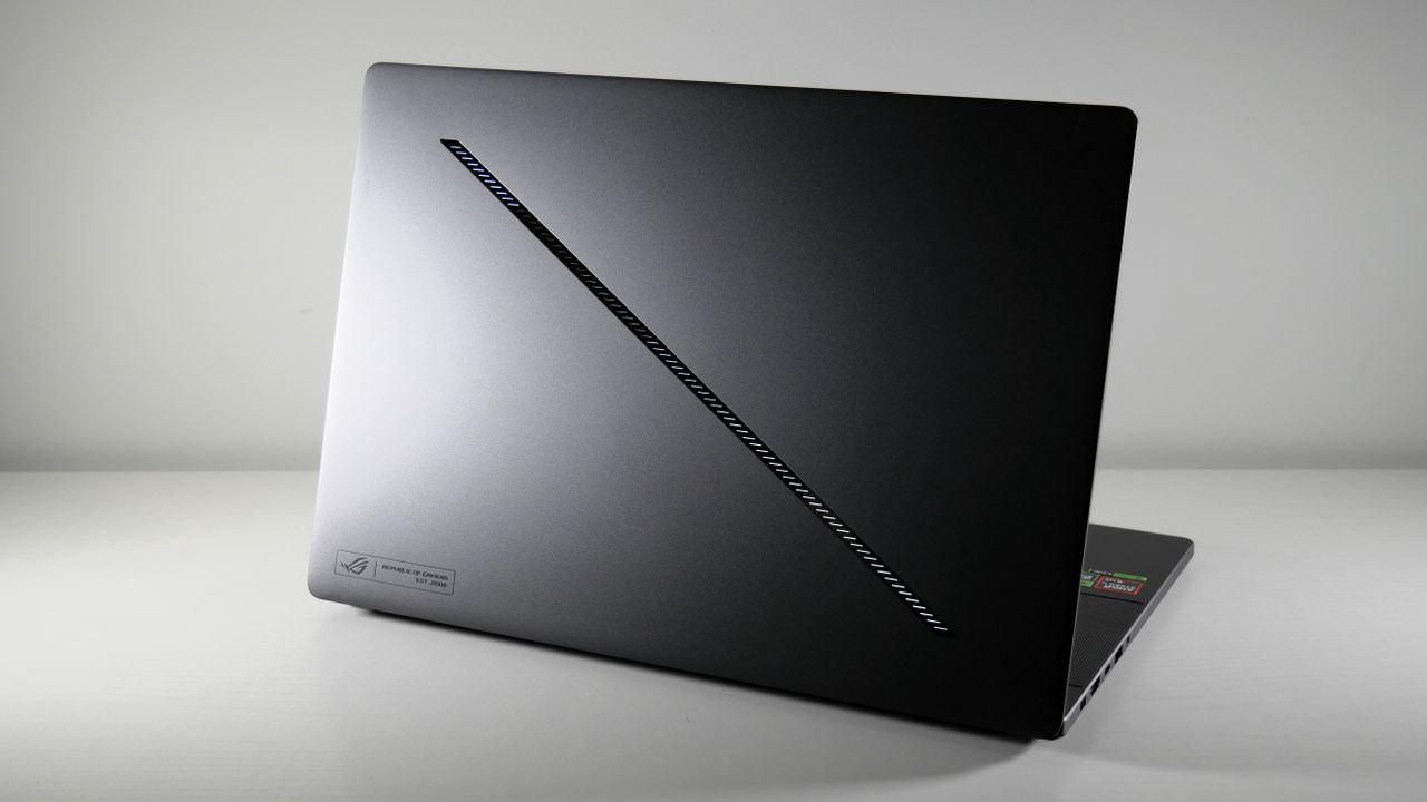 Asus ROG Zephyrus G16 (Ryzen AI 9) open with its lid facing the camera. It's a black-gray colorway with an LED-lit diagonal slash across it.