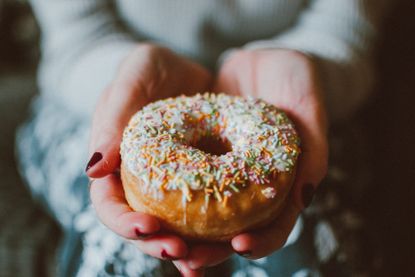 Image of someone holding a doughnut