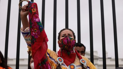 A demonstrator holds up her fist in front of the White House during a climate march in honor of Indigenous Peoples’ Day at on October 11, 2021 in Washington, DC. Activists organized the march to the White House to demand that U.S. President Joe Biden stop approving fossil fuel projects and declare a climate emergency, ahead of the United Nations climate summit in November.